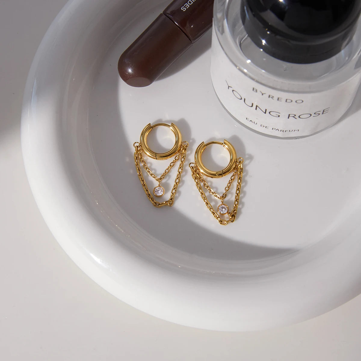 brinco feminino com corrente e ponto de luz